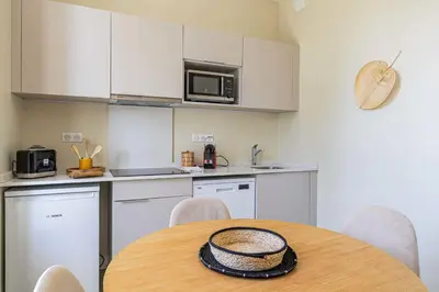 a kitchen with a table with chairs and a microwave at Quiet and luxurious studio - Cannes Center in Cannes