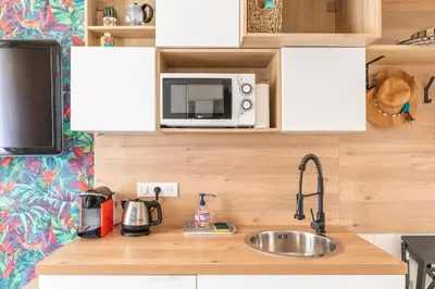 a kitchen counter with a sink and a microwave at Tapualiki studio cosy tout confort in Cannes