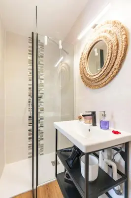 a bathroom with a sink and a shower with a mirror at Tapualiki studio cosy tout confort in Cannes