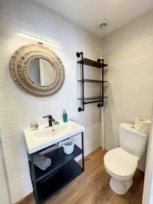 a bathroom with a toilet and a sink and a mirror at Tapualiki studio cosy tout confort in Cannes