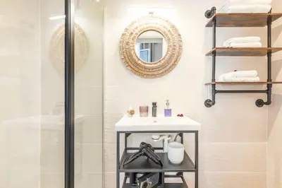 a bathroom with a shower and a sink and a mirror at Tapualiki studio cosy tout confort in Cannes