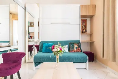 a living room with a blue couch and purple chairs at Tapualiki studio cosy tout confort in Cannes