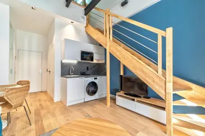 a living room with a staircase and a tv at Appartement Croisette Cannes centre in Cannes