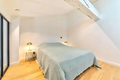 a white bedroom with a bed and a window at Appartement Croisette Cannes centre in Cannes