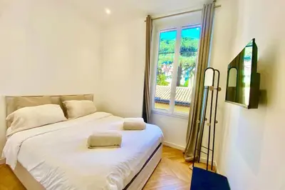 a bedroom with a white bed and a window at KEEP IN TOUCH 3 BEDROOM/3 BATHROOM/WIFI in Cannes
