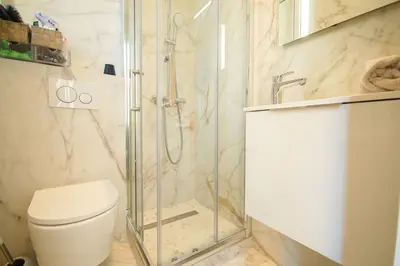 a bathroom with a toilet and a glass shower at KEEP IN TOUCH 3 BEDROOM/3 BATHROOM/WIFI in Cannes