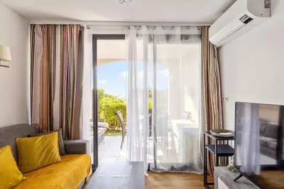 a living room with a couch and a sliding glass door at Appartement Wemyssia - Welkeys in Cannes