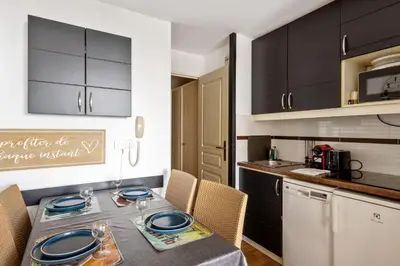 a kitchen with a table with blue plates on it at Appartement Wemyssia - Welkeys in Cannes