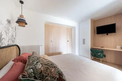 a bedroom with a bed and a flat screen tv at Beautiful flat with terrace - Carre d'Or Cannes in Cannes