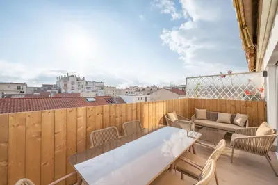 a balcony with a table and chairs and a couch at Beautiful flat with terrace - Carre d'Or Cannes in Cannes