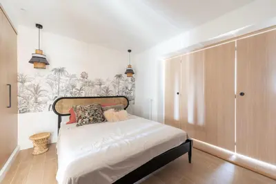 a bedroom with a bed with a wooden headboard at Beautiful flat with terrace - Carre d'Or Cannes in Cannes