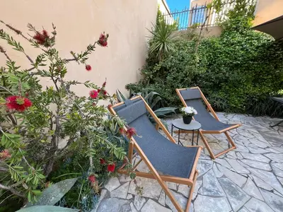 two chairs and a table on a patio with flowers at Quartier Suquet Marché Forville 4 pers. Terrasse in Cannes