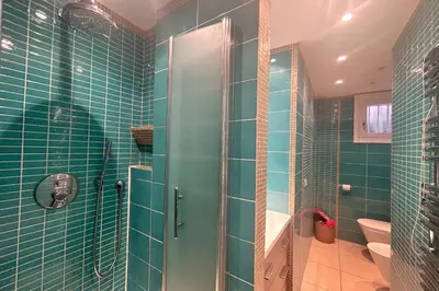 a bathroom with blue tiles and a shower with a glass door at Haven of peace overlooking the Croisette in Cannes