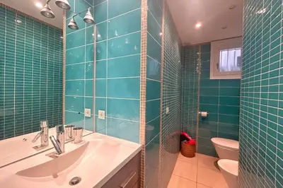 a green tiled bathroom with a sink and a toilet at Haven of peace overlooking the Croisette in Cannes