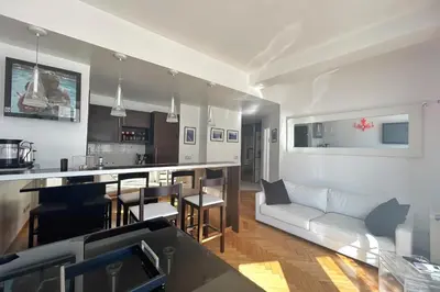 a living room with a white couch and a kitchen at Haven of peace overlooking the Croisette in Cannes