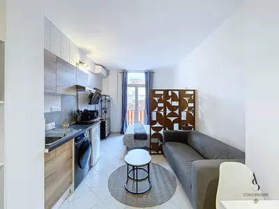 a living room with a couch and a kitchen at L'horloge I - Studio - 15 min Palais - Cannes in Cannes