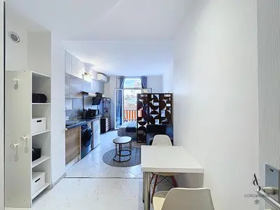 a kitchen and living room with a table and chairs at L'horloge I - Studio - 15 min Palais - Cannes in Cannes