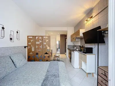 a large bedroom with a bed and a kitchen at L'horloge I - Studio - 15 min Palais - Cannes in Cannes