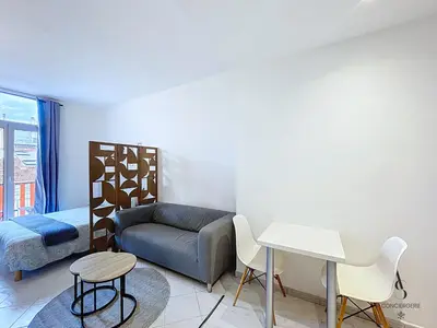 a bedroom with a couch and a bed and a table at L'horloge I - Studio - 15 min Palais - Cannes in Cannes