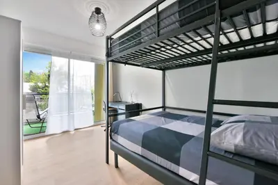 a bedroom with a bunk bed and a desk at Le Sun Valley - Vidéoprojecteur et Terrasse Zen in Cannes