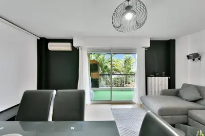 a living room with a couch and a glass table at Le Sun Valley - Vidéoprojecteur et Terrasse Zen in Cannes