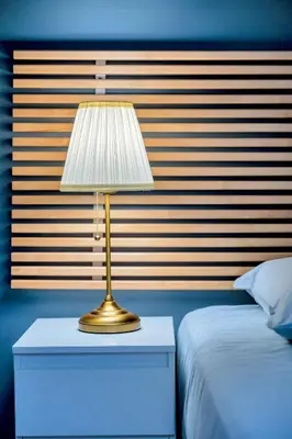 a lamp on a night stand next to a bed at Le Sun Valley - Vidéoprojecteur et Terrasse Zen in Cannes