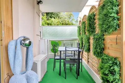 a balcony with green flooring and a table and chairs at Le Sun Valley - Vidéoprojecteur et Terrasse Zen in Cannes