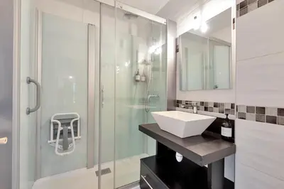 a bathroom with a sink and a glass shower at Le Sun Valley - Vidéoprojecteur et Terrasse Zen in Cannes
