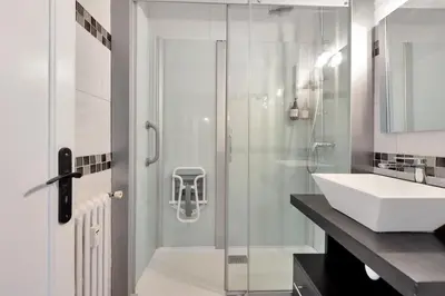 a bathroom with a glass shower and a sink at Le Sun Valley - Vidéoprojecteur et Terrasse Zen in Cannes