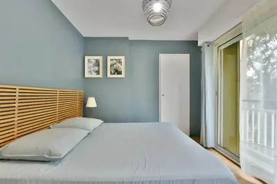 a bedroom with a large bed and a window at Le Sun Valley - Vidéoprojecteur et Terrasse Zen in Cannes