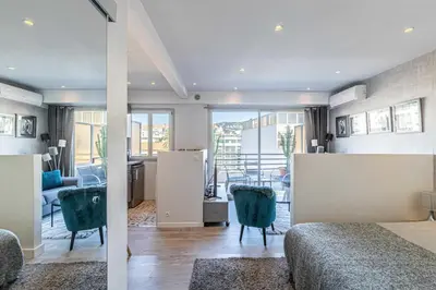 a bedroom with two beds and a living room at Magnificent studio with terrace - center of Cannes in Cannes