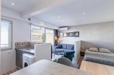 a room with a kitchen and a living room at Magnificent studio with terrace - center of Cannes in Cannes