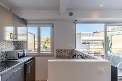 a kitchen with a sink and a large window at Magnificent studio with terrace - center of Cannes in Cannes