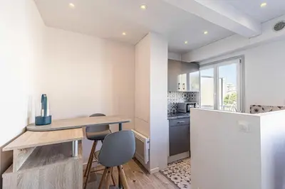 a kitchen with a wooden table and a refrigerator at Magnificent studio with terrace - center of Cannes in Cannes