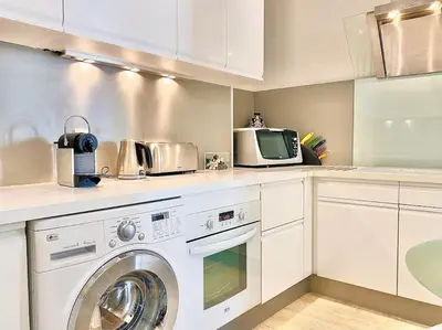 a kitchen with a washing machine and a microwave at Appartements Cannes 3 chambres - 8B1 in Cannes