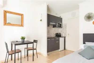 a kitchen and dining room with a table and chairs at L'Ariane - Studio - 5 min Plage - Climatisé in Cannes