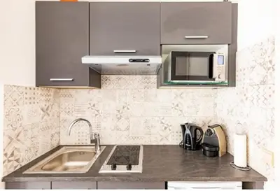 a kitchen with a sink and a microwave at L'Ariane - Studio - 5 min Plage - Climatisé in Cannes