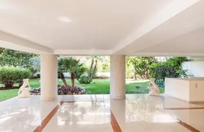 a large white room with columns and a garden at L'Ariane - Studio - 5 min Plage - Climatisé in Cannes