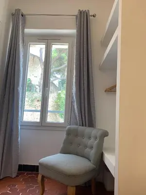 a chair in a room with a window at THE HEART OF CANNES 5MIN BY LA CROISETTE AND BEACH in Cannes