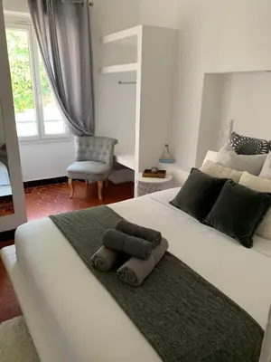 a bedroom with a large white bed with towels on it at THE HEART OF CANNES 5MIN BY LA CROISETTE AND BEACH in Cannes