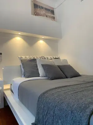a bedroom with a large bed with gray pillows at THE HEART OF CANNES 5MIN BY LA CROISETTE AND BEACH in Cannes