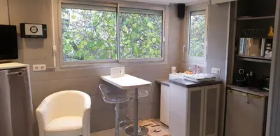 a bathroom with a sink and a chair and two windows at Studio Croisette in Cannes
