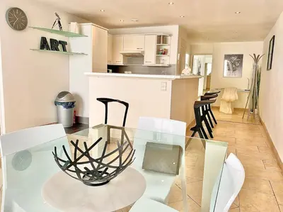 a dining room and kitchen with a glass table and chairs at Appartement Cannes 3 chambres - 8B2 in Cannes