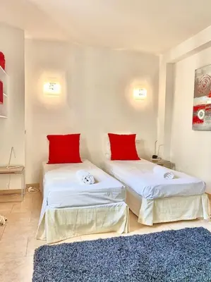 a room with two beds with red pillows and a rug at Appartement Cannes 3 chambres - 8B2 in Cannes