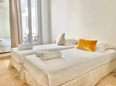two large white beds in a room with a window at Appartement Cannes 6 chambres - 8B3 in Cannes