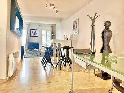 a living room with a table and some chairs at Appartement Cannes 6 chambres - 8B3 in Cannes