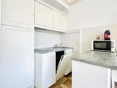 a white kitchen with a sink and a microwave at Le Splendide - studio croisette - vue mer in Cannes