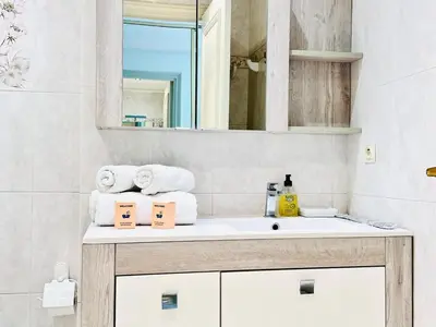 a bathroom with a sink and a mirror and towels at Le Splendide - studio croisette - vue mer in Cannes