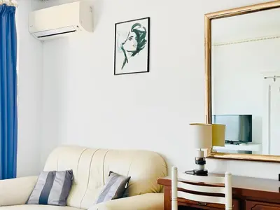 a living room with a couch and a mirror at Le Splendide - studio croisette - vue mer in Cannes