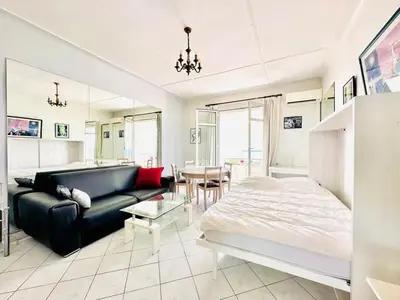 a bedroom with a bed and a couch and a table at Miramar - Studio Croisette - Vue Mer Panoramique in Cannes